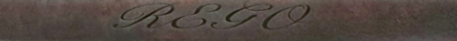 A strap of dark brown dyed leather with REGO engraved into it in flowing script.